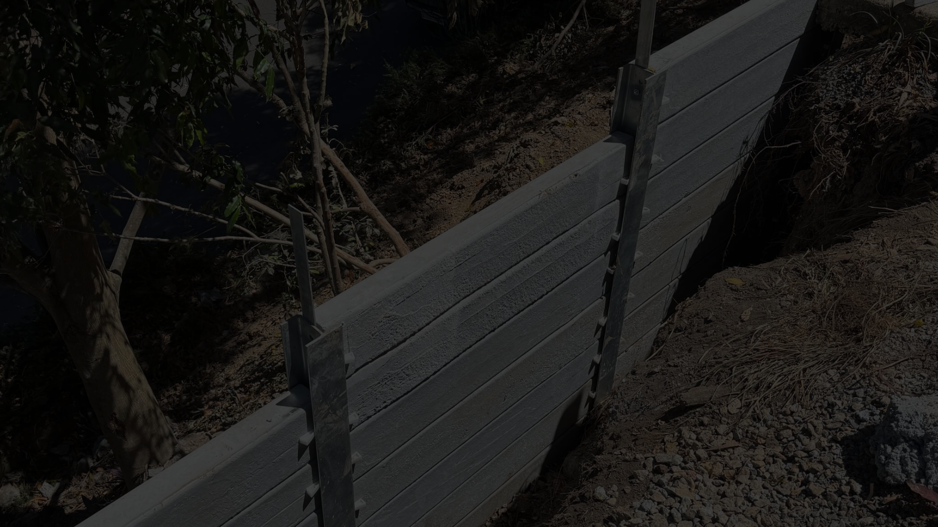 Retaining Wall Engineers Brisbane – concrete sleeper retaining wall installation on sloped site.