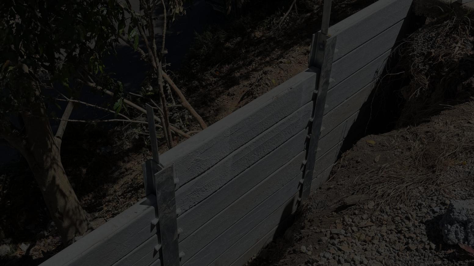 Retaining Wall Engineers Brisbane and Gold Coast â concrete sleeper retaining wall installation on sloped site.
