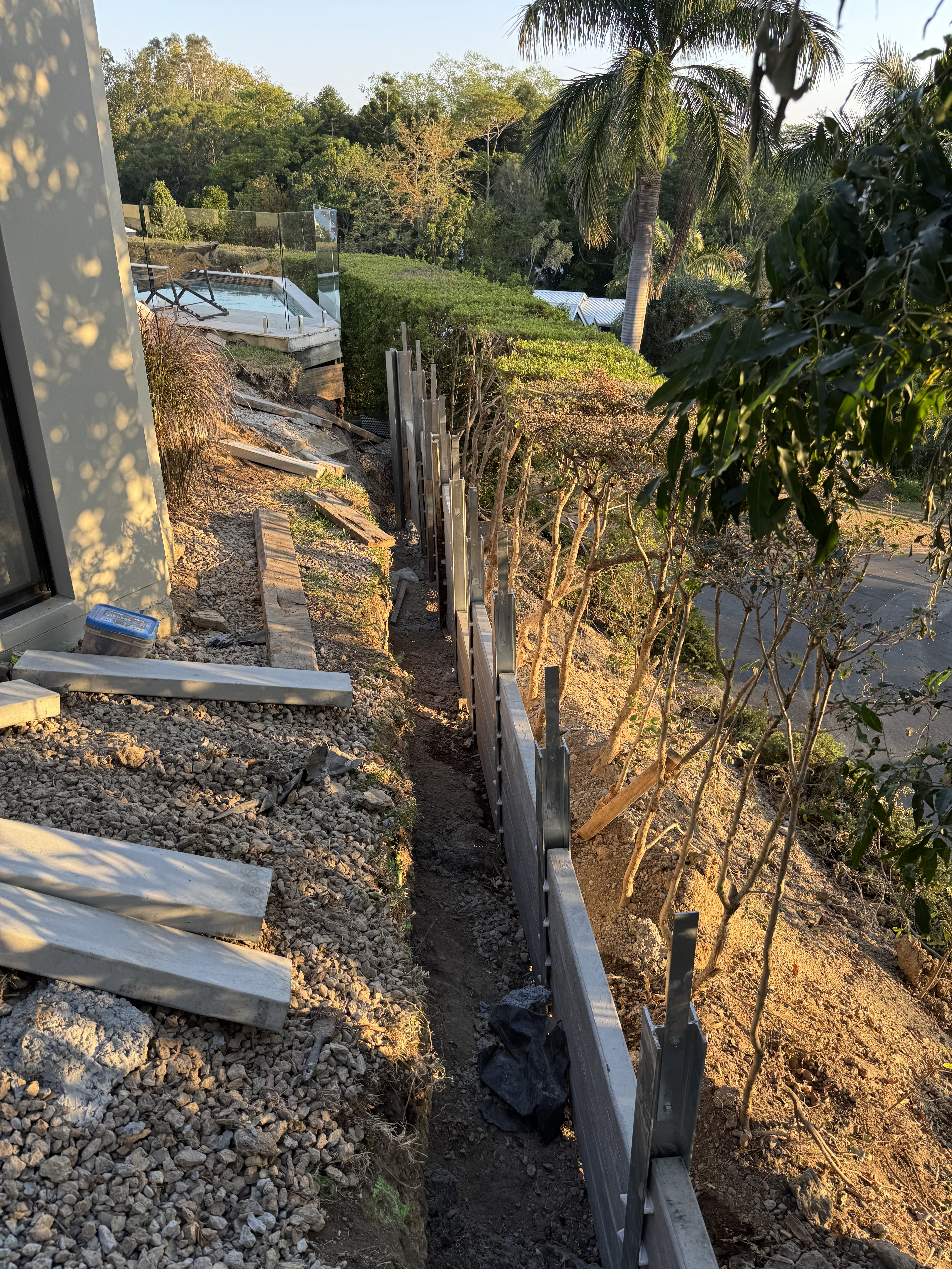 Sleeper retaining wall installation on steep site by Gold Coast retaining wall engineers